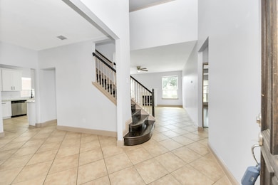The entryway welcomes with a sweeping staircase to