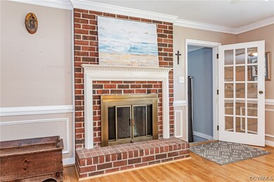 Living room featuring brick wall, a fireplace, lig