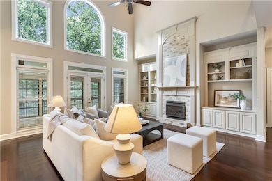 Large living room featuring arched windows, fireplace, Brazilian Cherry floors and bookcases