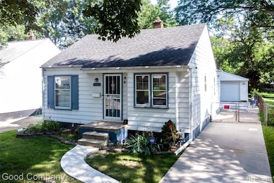 View of front facade featuring a chimney, roof with shingles, a garage, an outbuilding, and a gate
