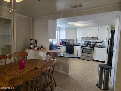 Kitchen with white cabinets, decorative backsplash