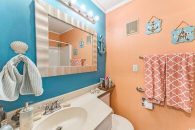 Bathroom featuring crown molding, a textured ceiling, a shower, vanity, and toilet