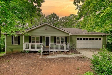 Single story home with an attached garage, covered porch, and concrete driveway
