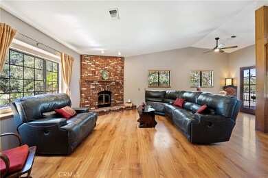 The living room features laminate wood floors, vaulted ceilings and a wood burning fireplace.