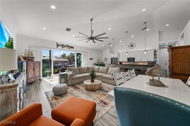 Living room with wood finished floors, ceiling fan, high vaulted ceiling, and recessed lighting