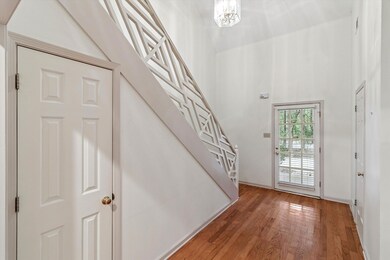 Entryway featuring stairs, light wood finished floors, and a high ceiling