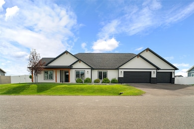 View of front of house with stone siding, driveway, a garage, and roof with shingles