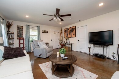 The spacious living room is complete with recessed lighting and a ceiling fan.
