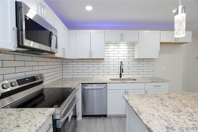 Kitchen featuring a sink, white cabinets, applianc