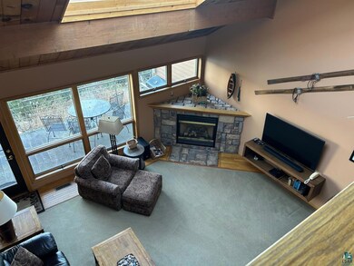 Carpeted living room featuring a fireplace and lof