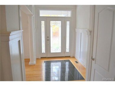 Foyer with marble inlay and leaded front door.