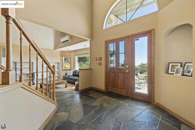 Tiled foyer entrance featuring a wall mounted air conditioner, french doors, and a towering ceiling