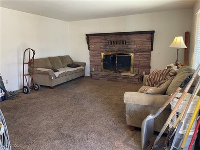 Carpeted living area with a stone fireplace