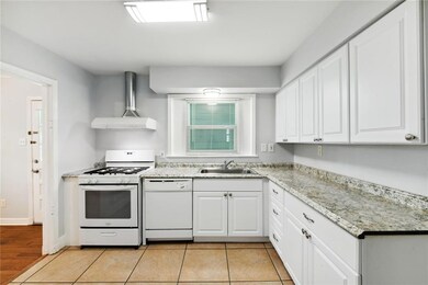 Kitchen includes gas stove with hood, dishwasher,