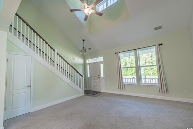 Carpeted entrance foyer featuring ceiling fan, sta