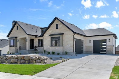 View of front facade featuring stone siding, an attached garage, concrete driveway, and roof with shingles