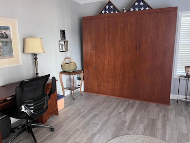 Office space featuring a healthy amount of sunlight, light wood-type flooring, and baseboards