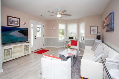 Living room with ceiling fan and light hardwood / 