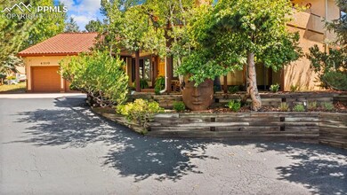 View of front of property featuring asphalt driveway, a tile roof, an attached garage, and stucco siding