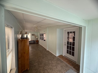 Sunroom with a paneled ceiling and a wall unit AC