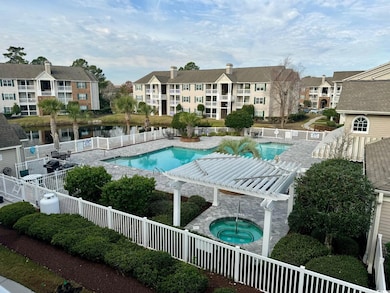 Community pool with a community hot tub, fence, and a residential view