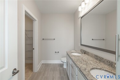 Bathroom featuring double vanity and a spacious closet