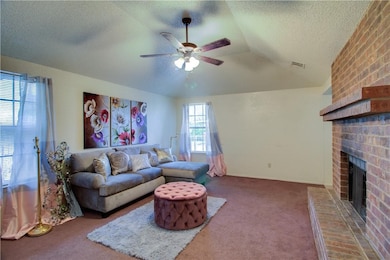 Carpeted living room with a fireplace, lofted ceiling and ceiling fan