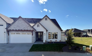 View of front of house with concrete driveway, an attached garage, a front lawn, stone siding, and stucco siding