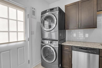 Clothes washing area featuring stacked washing ma
