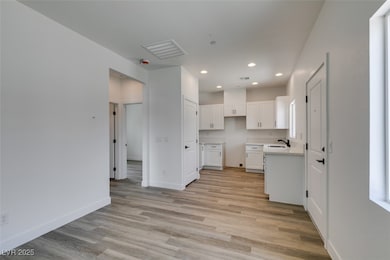 Kitchen featuring light wood-style floors, white c