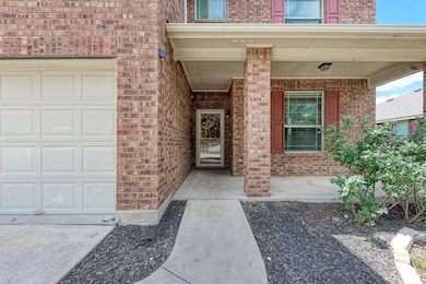 Property entrance with a garage, brick siding, an
