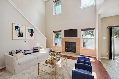 Living area featuring a tiled fireplace, baseboar