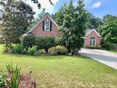 Traditional-style house featuring brick siding, a front yard, and concrete driveway