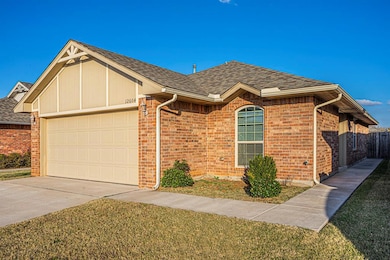 View of front of home featuring a garage, roof with shingles, driveway, and brick siding