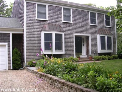 Perennial gardens line entrance to this pristine Colonial