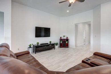 Living room featuring ceiling fan and recessed li