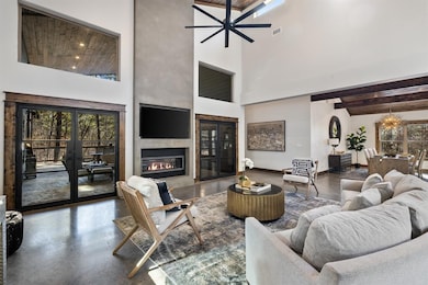 Living room featuring beam ceiling, a towering cei