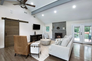 Living room with brick wall, ceiling fan, and dark hardwood / wood-style floors