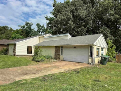 Mid-century home with an attached garage, a front lawn, a shingled roof, and concrete driveway