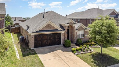View of front of property featuring central AC unit, a front yard, and a garage