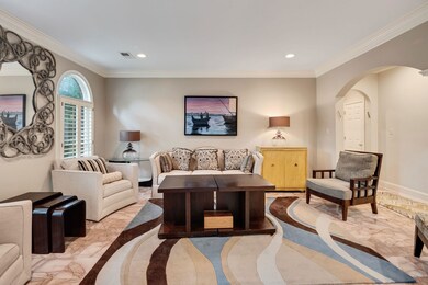 Living room featuring arched walkways, recessed lighting, crown molding, and baseboards
