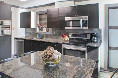 Kitchen with island, new dishwasher and refigerator.