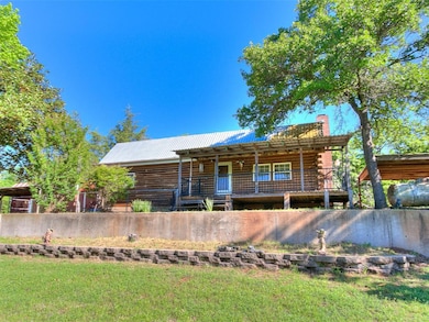 Log cabin with a chimney, metal roof, and a front 