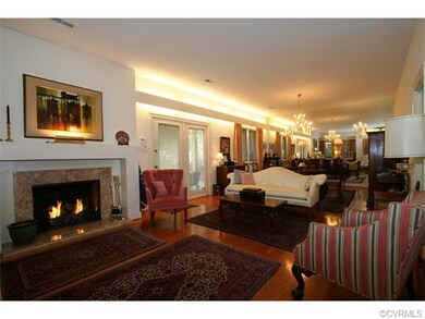 Living room is open to the dining room area and features a wood burning fireplace with gas log.