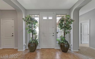 Tiled entryway featuring arched walkways and plent