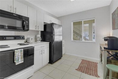 Kitchen featuring black appliances, white cabinetr