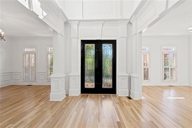 Entryway with french doors, a decorative wall, lig