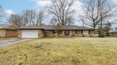 Ranch-style house featuring a garage and a front lawn