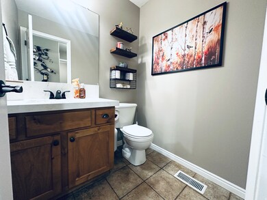 Half bath with vanity and dark tile patterned flooring