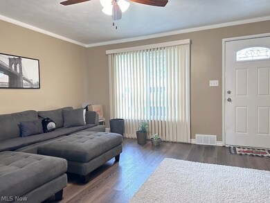 Living room featuring crown molding, dark hardwood / wood-style floors, and ceiling fan